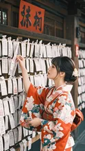 A woman drawing omikuji fortune slips, countless fortunes tied on a wooden rack, kimono sleeves, Japanese color palette, natural light, close-up, film look, ultra-detailed — レイ@お絵かきさんのAIイラスト