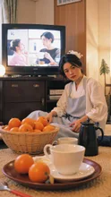 Mikan oranges and tea on a kotatsu, New Year TV program in the background, relaxed afternoon, cozy everyday realism, natural colors, ultra-detailed — yuna97さんのAIイラスト